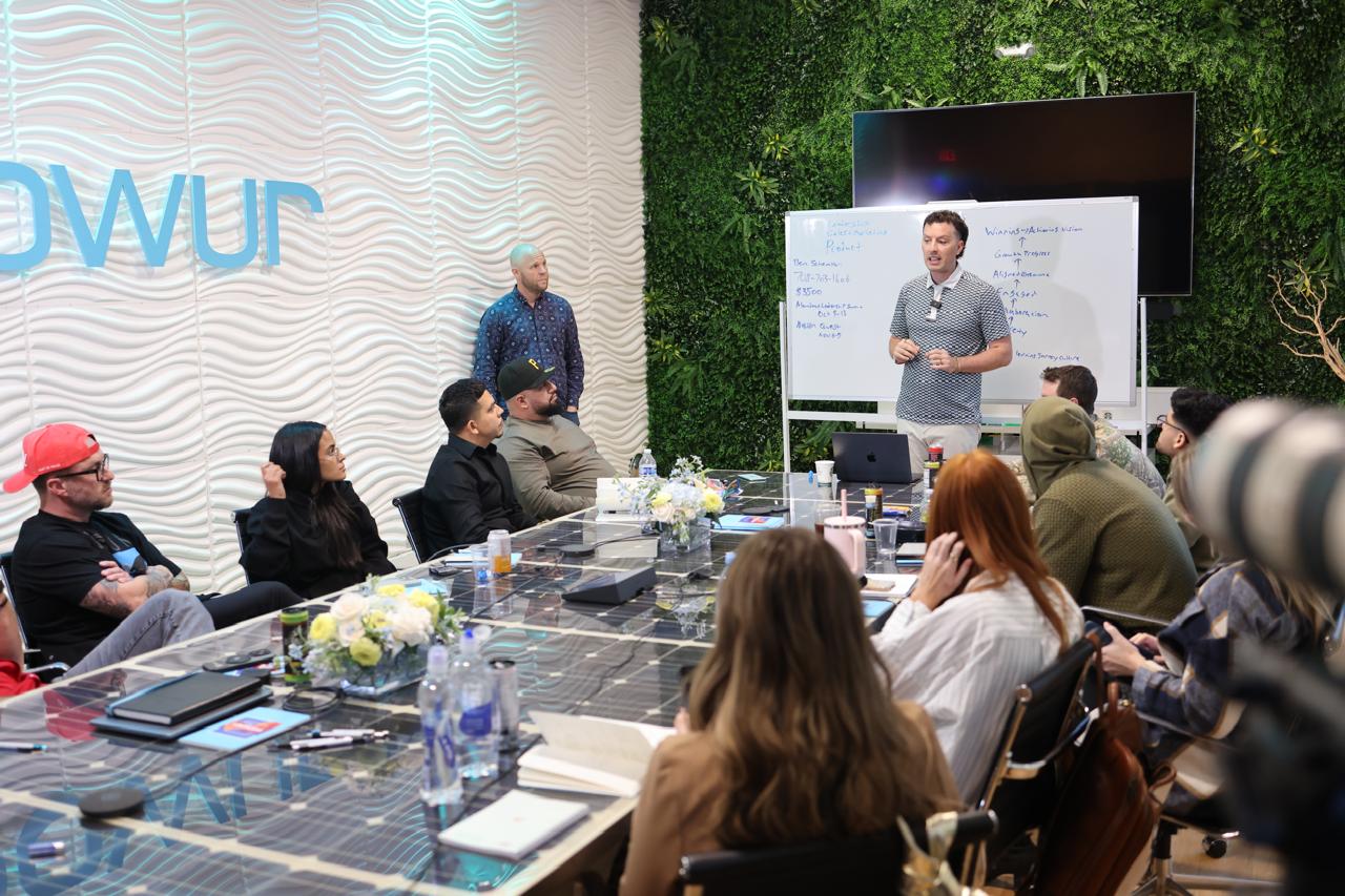Danny Pessy coaching a room of sales professionals around a conference table